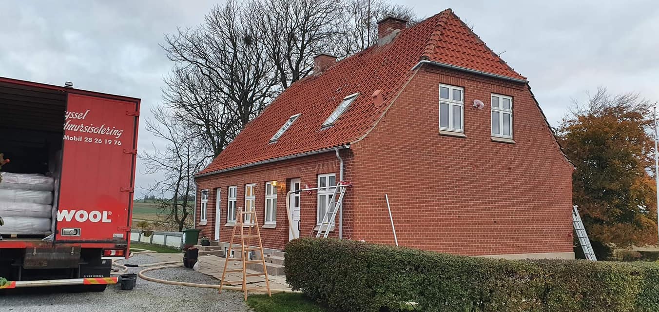 Insulation truck near red brick house